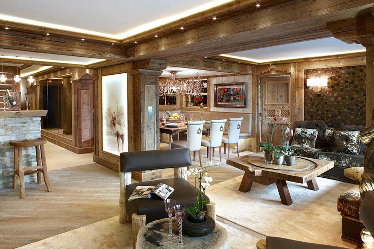 Bar counter with high chairs next to living area in Apartment Albaron in Courchevel 1850