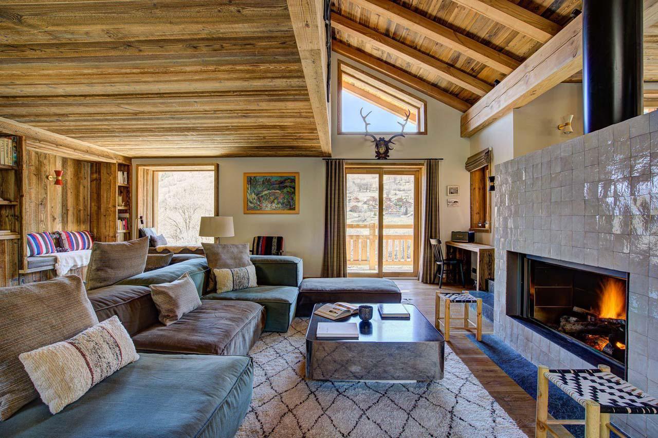 Open-plan living area with feature fireplace at Chalet Bergeronnette in Meribel