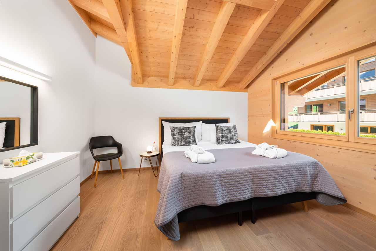 Double bedroom with wooden beamed ceiling at Chalet Columba at Grindelwald