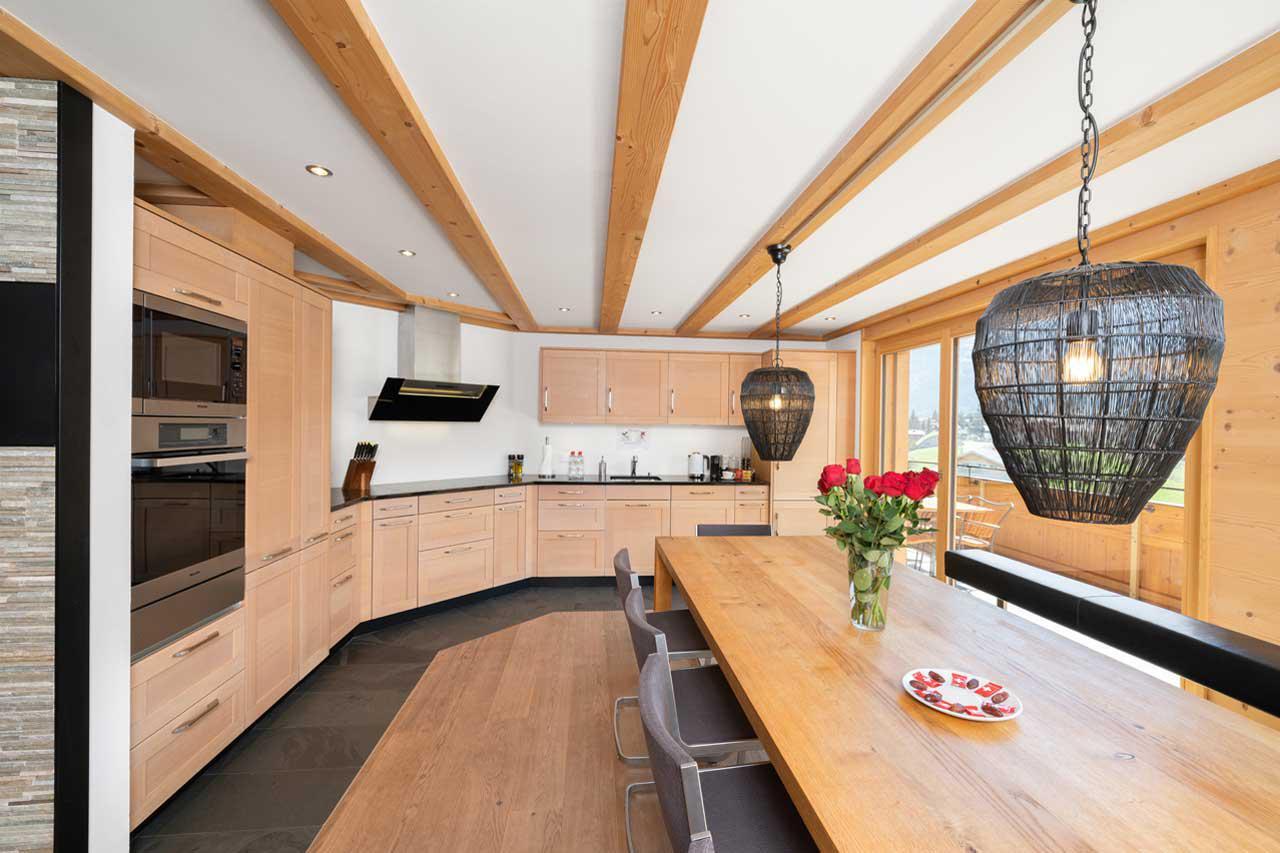 Kitchen and dining table with modern wooden design at Chalet Columba at Grindelwald