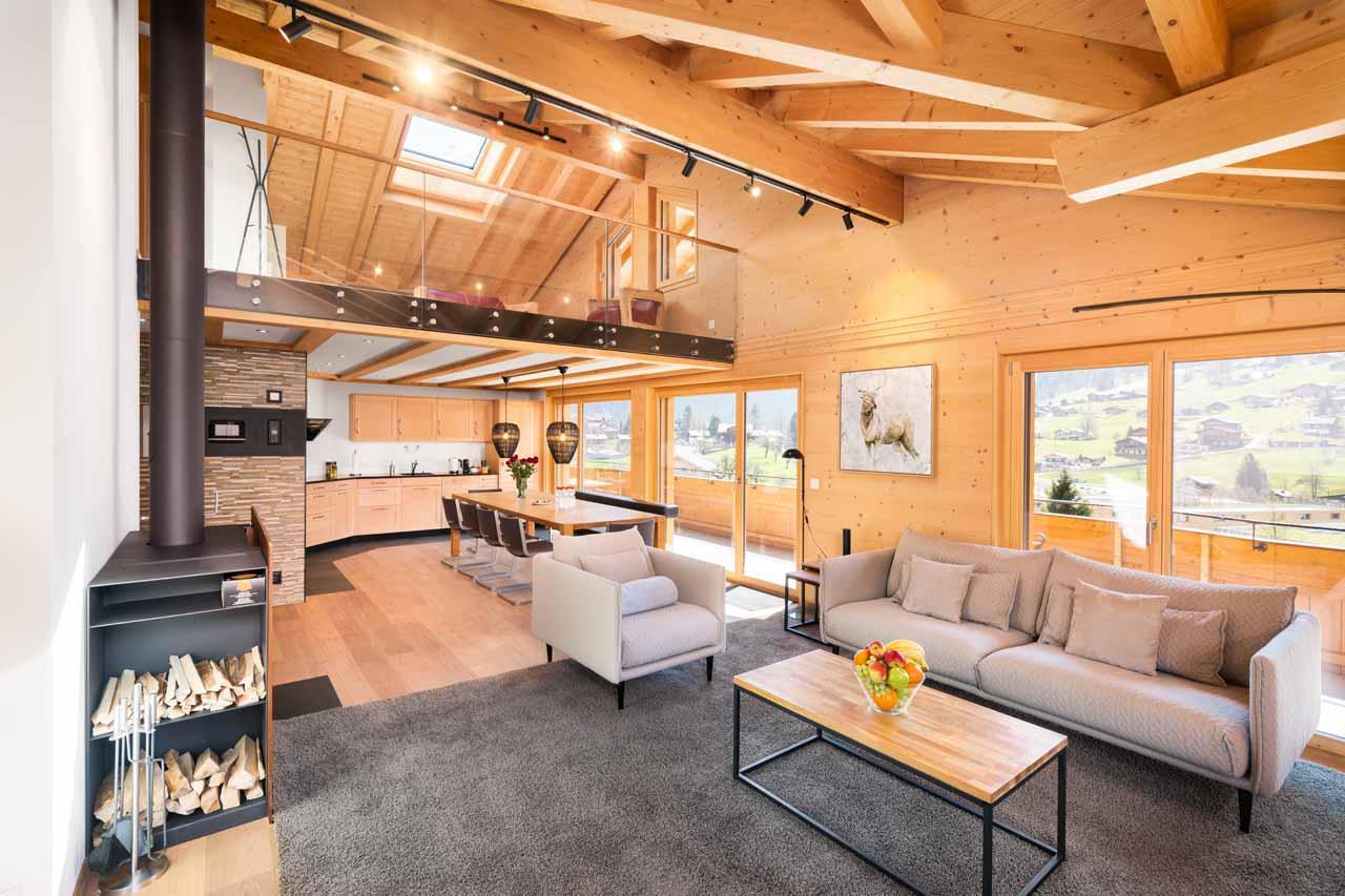 Open-plan living room with sofas, dining table and kitchen at Chalet Columba at Grindelwald